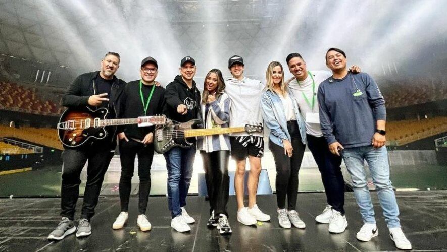 Black and white portrait of a dance instructor posing in front of a dark background.