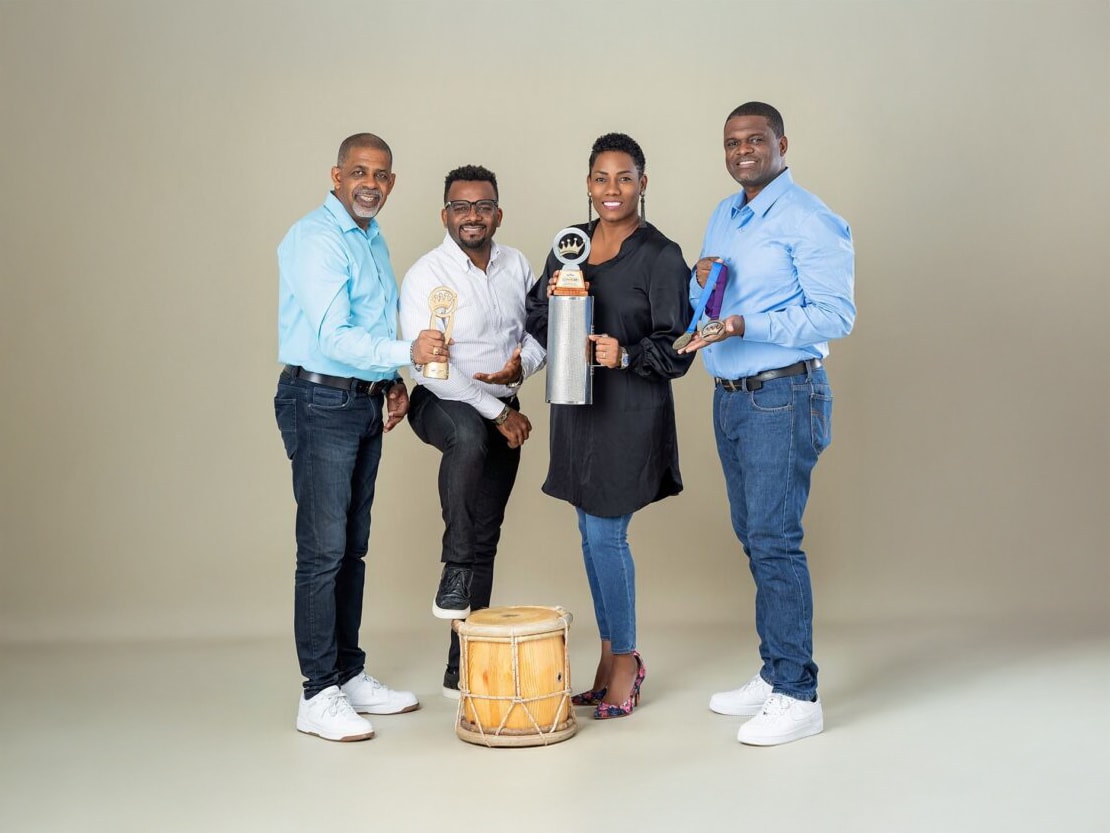 Black and white portrait of a dance instructor posing in front of a dark background.